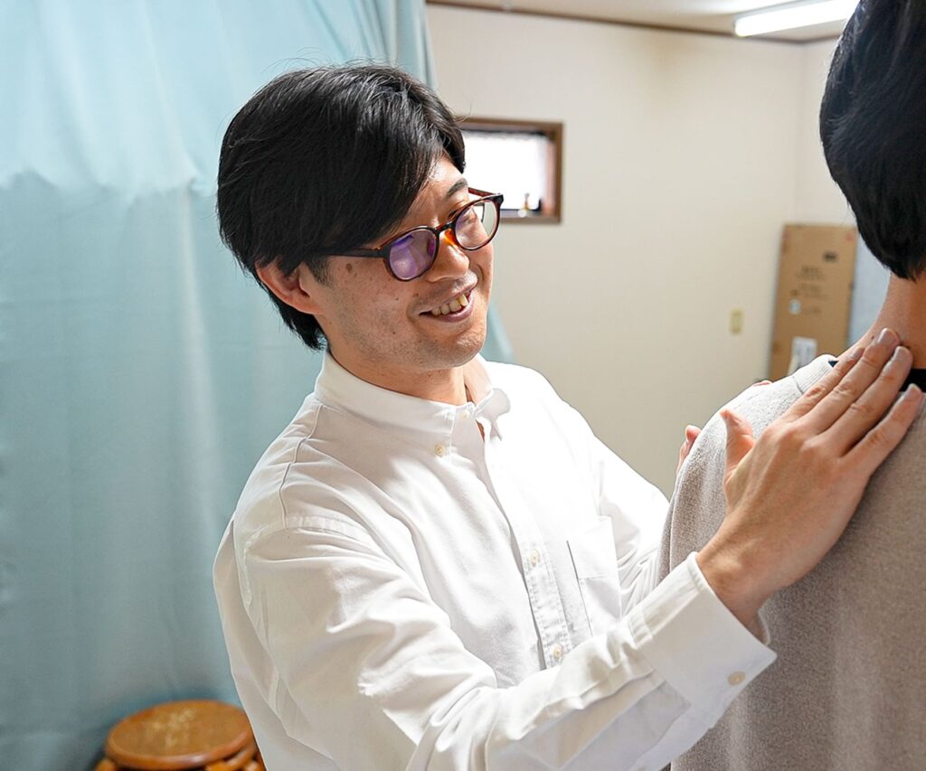 背中のチェックをするボラン整体院の代表